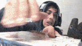 a man wearing headphones is cutting a piece of paper