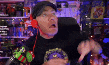 a man wearing headphones is giving a thumbs up in front of a nintendo sign