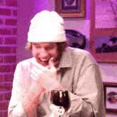 a man wearing a white hat is holding a glass of wine