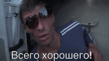 a man wearing sunglasses and a blue shirt is standing in a doorway with the words " всего хорошего " on the bottom right