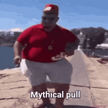 a man in a red shirt and white shorts is standing on a beach with the words mythical pull below him
