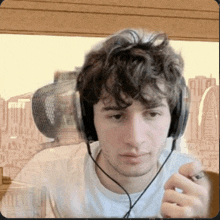 a young man wearing headphones looks at the camera