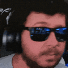 a man wearing headphones and sunglasses is looking at the camera