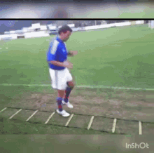 a man in a blue shirt and white shorts is running on a soccer field .
