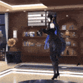 a woman in a black dress stands in front of a record player