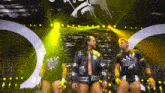 a group of wrestlers are standing on a stage and one of them is wearing a shirt that says aew on it