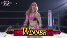 a woman in a wrestling ring with the word winner on the bottom