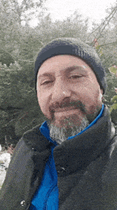 a man with a beard wearing a black hat