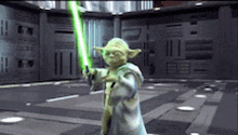 yoda is holding a green lightsaber in a room .