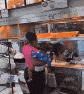 a woman in a pink shirt is holding a baby in a restaurant .