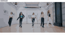 a group of women are dancing in a room with a sign that says wine entertainment