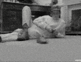a black and white photo of a man laying on the floor with the words vevc on the bottom right
