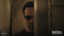 a poster for daredevil born again shows a man in sunglasses