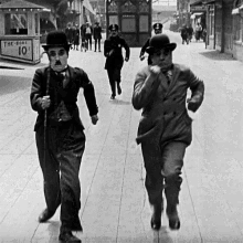 two men are running down a street in front of a booth that says the boss 10 %