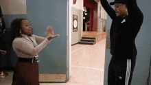 a man and a woman are giving each other a high five .