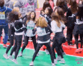a group of girls are dancing on a track and one of them has a name tag that says 2