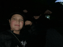 a young boy wearing a black shirt that says yan