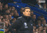 a man stands in front of a crowd with the word albion on the bottom right corner