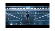 a woman in a futuristic outfit is dancing on stage