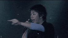 a man singing into a microphone with the letter d visible in the corner