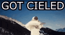 a man in a white coat stands in front of a snowy mountain with the words got cieled written above him