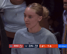 a woman stands in front of a scoreboard that says was 71 dal 79