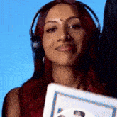 a woman with red hair and headphones is holding a picture
