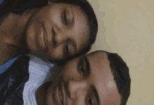 a man and a woman are laying next to each other and smiling .