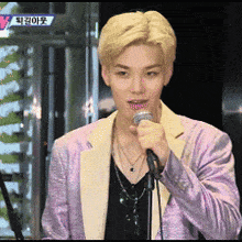 a man in a purple jacket holds a microphone