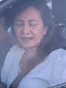 a woman is sitting in a car with a red sticker that says ayaw