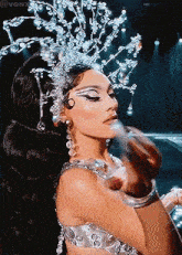 a woman with a crown on her head is getting her makeup done