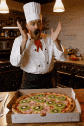 a chef is looking at a pizza with kiwi slices on it