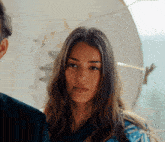 a close up of a woman 's face with a man in the background