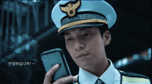 a man in a police uniform holds a cell phone in his hand