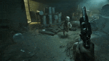 a group of people are standing in a room with barrels on the floor