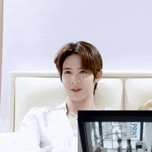 a man sitting on a bed with a picture frame that says print