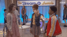 a group of kids are standing in front of a sign that says stream-o awards
