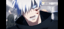 a close up of a man with white hair and a black hoodie .