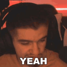 a man wearing headphones is making a funny face while saying yeah .