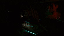 a person sitting in a dark room with a green light on