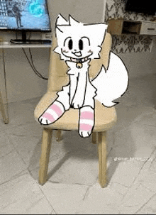 a white cat is sitting on a chair with striped socks on .