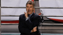 a man in a suit and tie is making a face