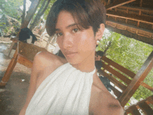 a woman in a white dress takes a selfie in front of a gazebo