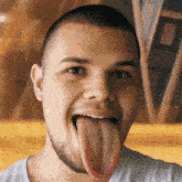 a man with a long tongue sticking out looks at the camera