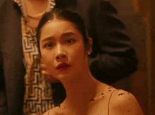 a close up of a woman 's face with a man behind her