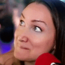 a close up of a woman 's face with a red hat on her head .