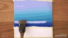 a brush is being used to paint a picture of a beach made by chloe art