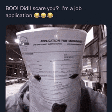 a person is holding a paper that says application for employment on it