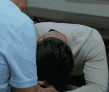 a man is holding a woman 's head while laying down