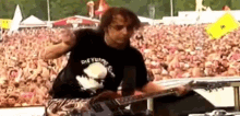 a man is playing a guitar in front of a crowd while wearing a shirt that says one yuffie
